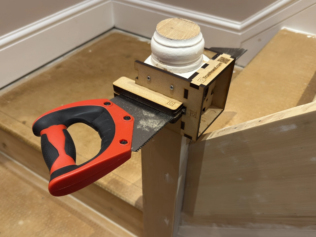 TrueNewel 90 screwed to a 90mm stair newel post with a hand saw in the guide